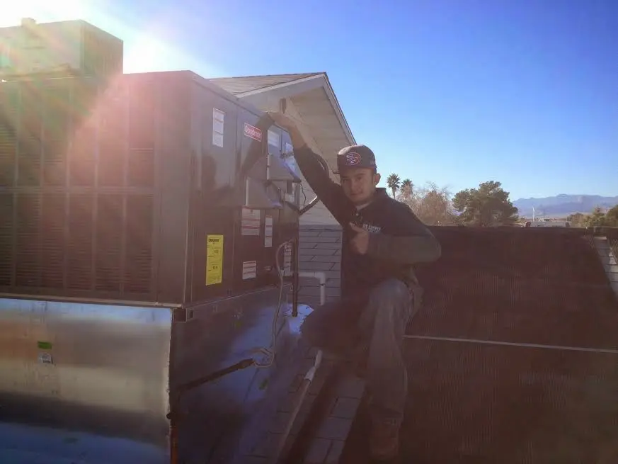 HVAC technician performing Heat Pump Repair on a rooftop unit in Raceland